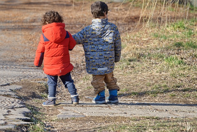 Two children stroll down a winter path, embracing the fun and excitement of their winter break camp experience.