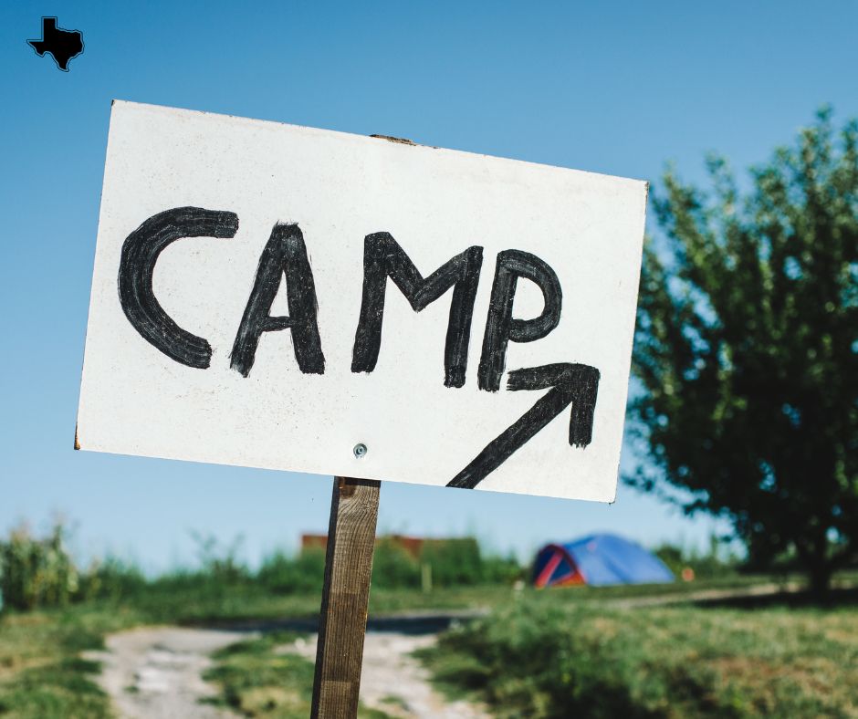 Camping sign indicating the direction to the campground, set against a summer backdrop in Dallas.