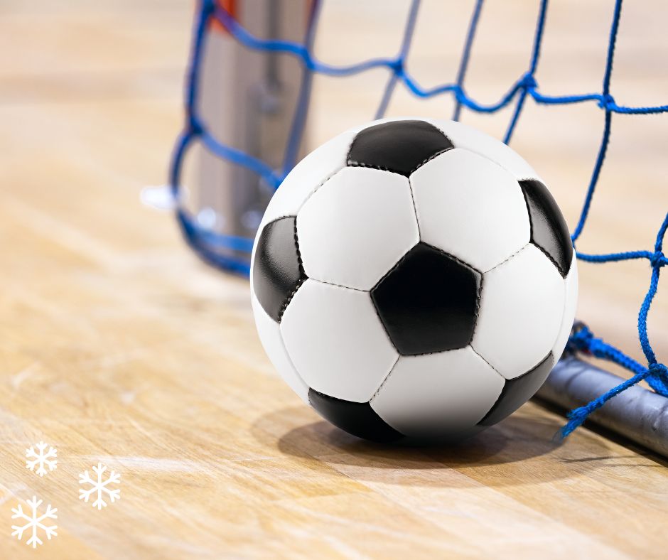 A soccer ball rests on the ground beside a net, symbolizing winter break camp activities and sports engagement.