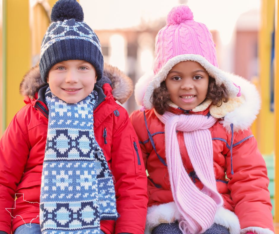 Two children in winter gear happily seated on a slide at Camp Mania, recognized as one of the best nature camps in Southlake, Texas.