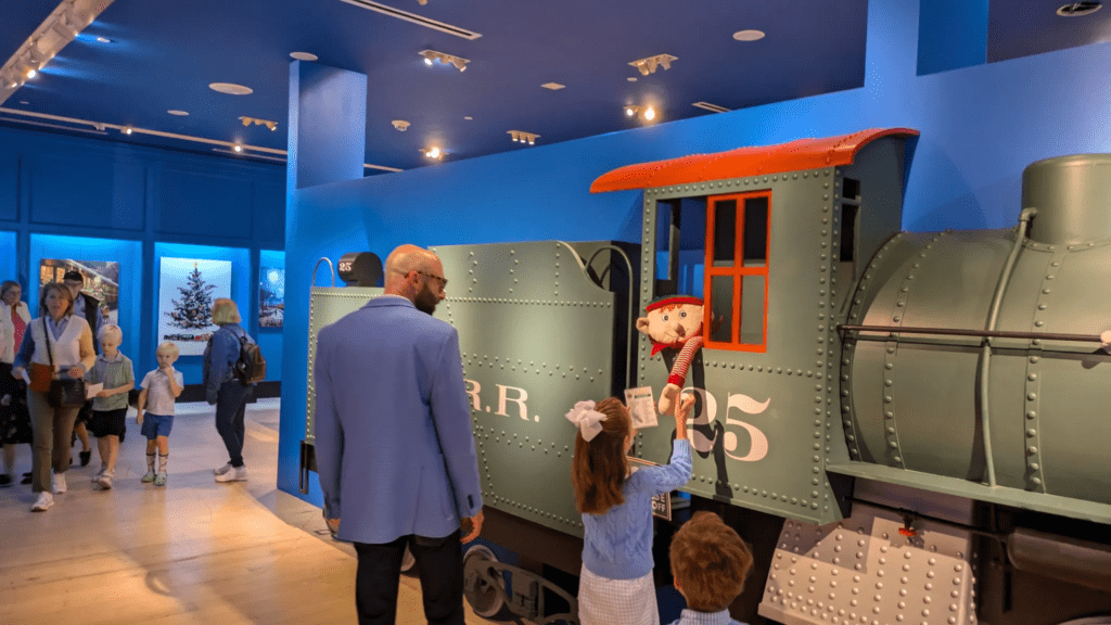 Visitors, including kids, exploring a train exhibit in a museum, representing fun and educational nighttime options in Dallas.