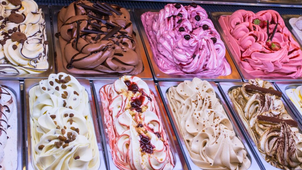 A variety of colorful ice cream flavors displayed in trays, perfect for a fun night out in Dallas with family.