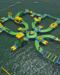 Kids and adults enjoying inflatable obstacle course at WhoaZone Water Park during summer group outings